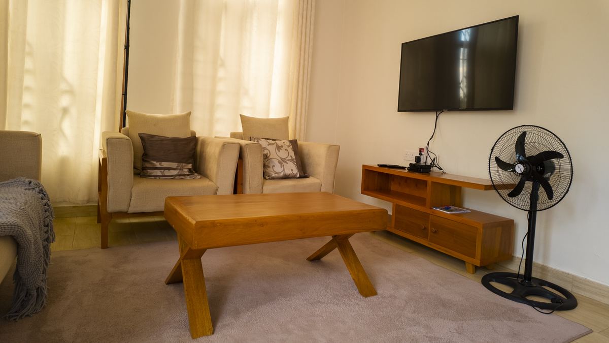 Sitting room with armchairs, coffee table and wall TV